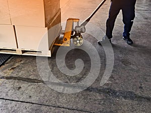 Worker driving forklift loading shipment carton boxes goods on wooden pallet at loading dock from container truck to warehouse car