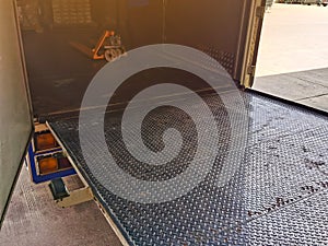 Worker driving forklift loading and unloading shipment carton boxes and goods on wooden pallet from container truck to warehouse