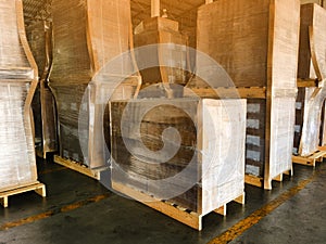 Worker driving forklift loading and unloading shipment carton boxes and goods on wooden pallet from container truck to warehouse c