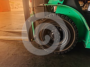 Worker driving forklift loading and unloading shipment carton boxes and goods on wooden pallet from container truck to warehouse c