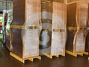 Worker driving forklift loading and unloading shipment carton boxes and goods on wooden pallet from container truck to warehouse c