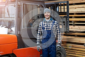 Worker driving forklift in lumber yard