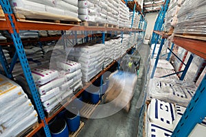 Worker driving forklift in warehouse