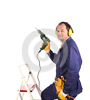 Worker in ear muffs and glasses with drill.