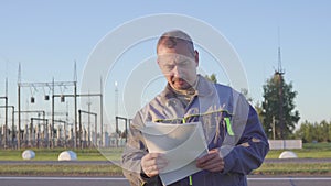 Worker at Electrical Substation. Worker with blueprints and clipboard in meeting at electrical substation.