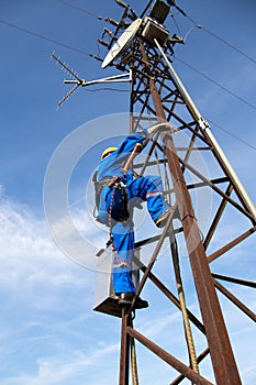 Worker, electrician is climbing on the electric power pole