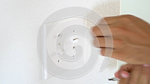 Worker electrician repair an electrical outlet in apartment
