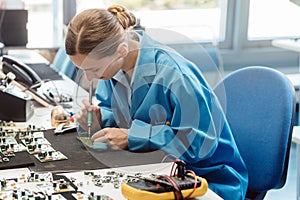 Worker in electronics manufacturing soldering a component