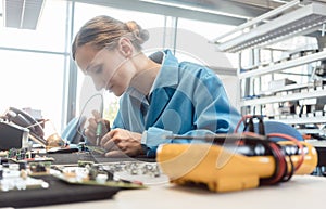 Worker in electronics manufacturing soldering a component