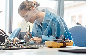 Worker in electronics manufacturing soldering a component