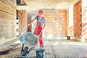 Worker with empty wheelbarrow on construction site