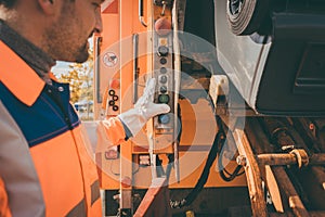 Worker emptying dustbin into waste vehicle