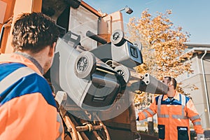 Worker emptying dustbin into waste vehicle