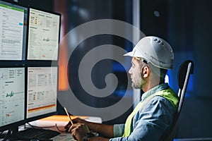 Worker engineer control process of production uses computer with modern SCADA system which showing AI and machine learning