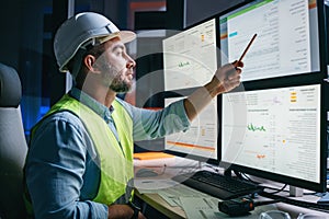 Worker engineer control process of production uses computer with modern SCADA system which showing AI and machine learning