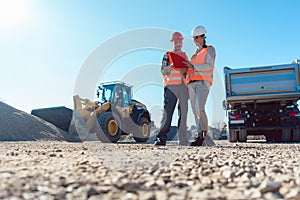 Worker and engineer on earthworks construction site planning