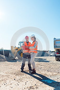 Worker and engineer on earthworks construction site planning photo