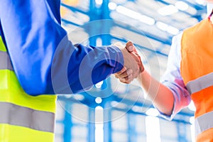 Worker and engineer handshake in factory