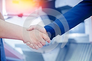 Worker engineer shaking hands with businessman at construction site background cnc control panel