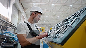 Worker On Factory Analyzes The Production Process And Programming Industrial CNC Machine Tool