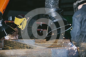 Worker at the factory in the helmet is of iron in the welding pr