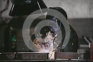 Worker at the factory in the helmet is of iron in the welding pr