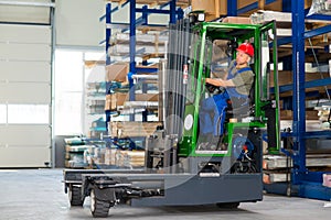 Worker in factory in lift truck with thumb up