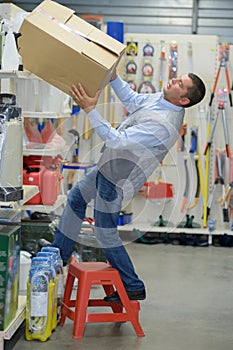 Worker falling off ladder in warehouse