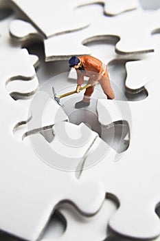 Worker figurine on puzzle pieces