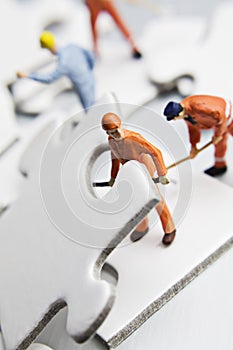 Worker figurine on puzzle pieces