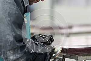 Worker filleting a stone slab edge