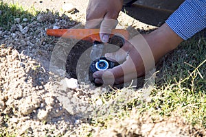 Worker fix lawn sprinkler