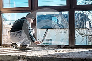 Worker fix a window using polyurethane foam