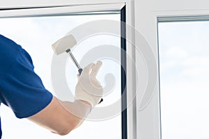 Worker fixes a double-glazed window in a frame of a plastic window