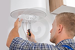 Worker Fixing Electric Boiler photo