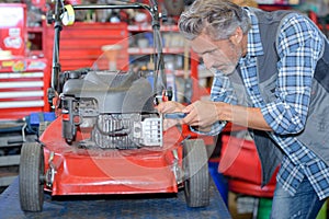 Worker fixing lawn mower