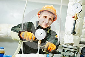 Worker fixing manometer in boiler room