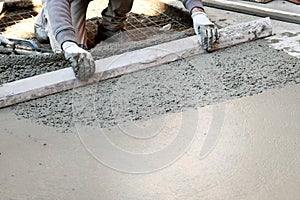 Worker flattening concrete floor
