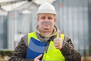 Worker with folder near the factory