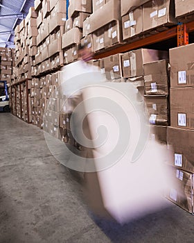 Worker with fork pallet truck stacker in warehouse