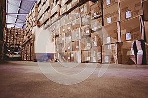 Worker with fork pallet truck stacker in warehouse