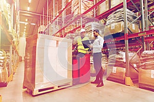 Worker on forklift and businessman at warehouse