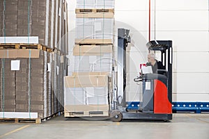 Worker In Forklift Examining Stockpile