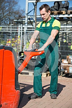 Worker with forklift in warehouse or storehouse