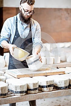 Worker forming ceramics at the pottery manufacturing