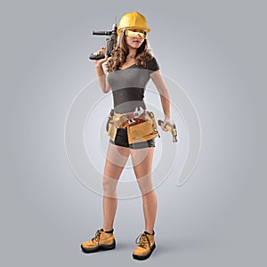 Worker girl in a helmet with drill and hammer