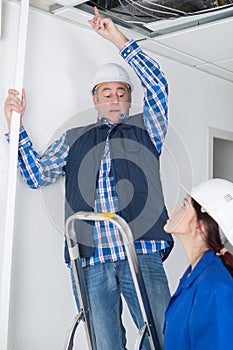 Worker giving instructions about wiring on ceiling