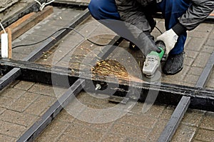 Worker in gloves cleans the angle grinder