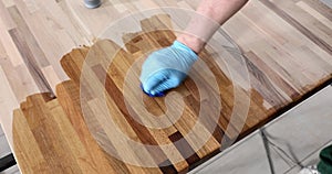 Worker in gloves oiling wooden board closeup 4k movie slow motion