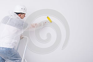 the worker glues the wallpaper with a roller  expelling air and glue